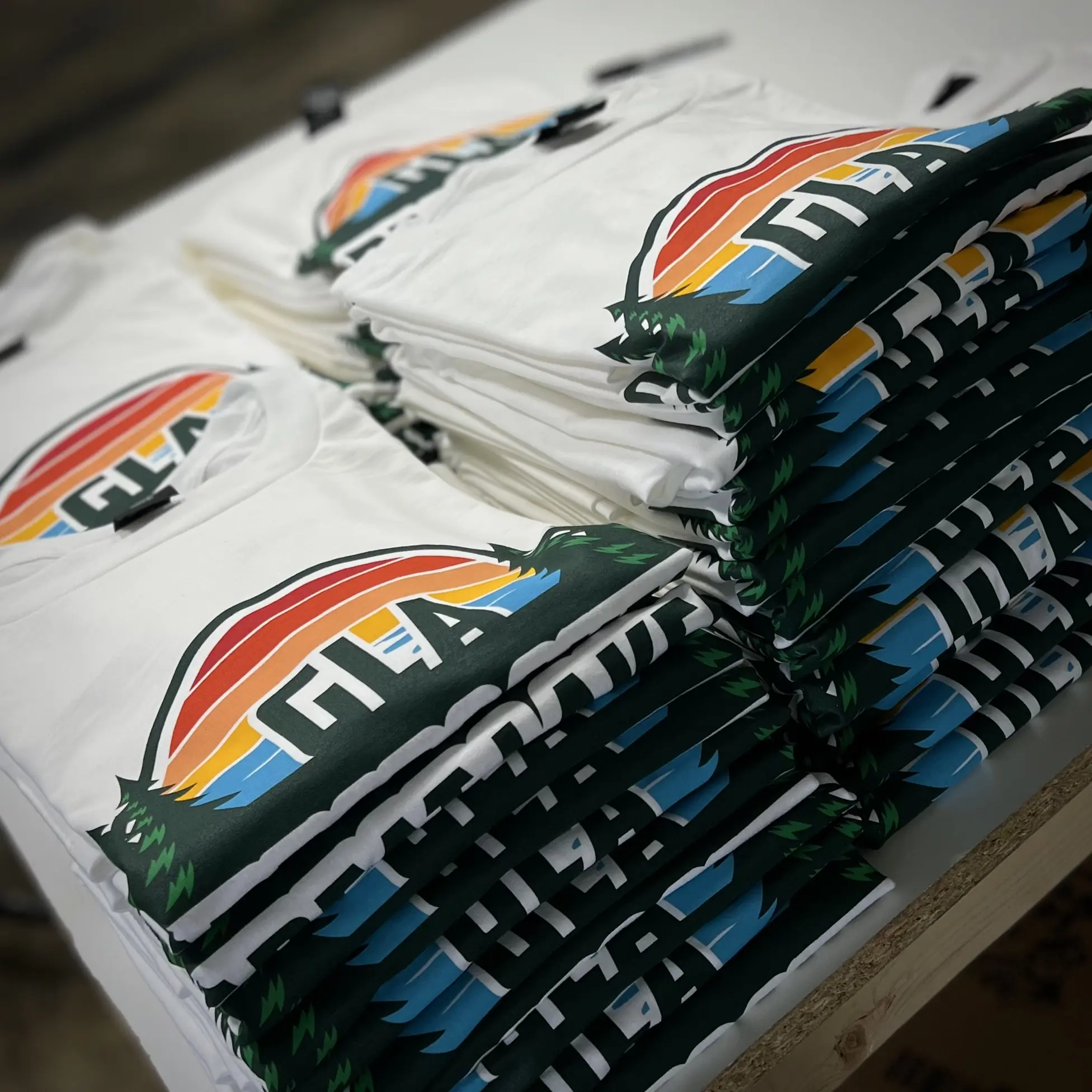 Stacks of finished white shirts with colorful printed artwork
