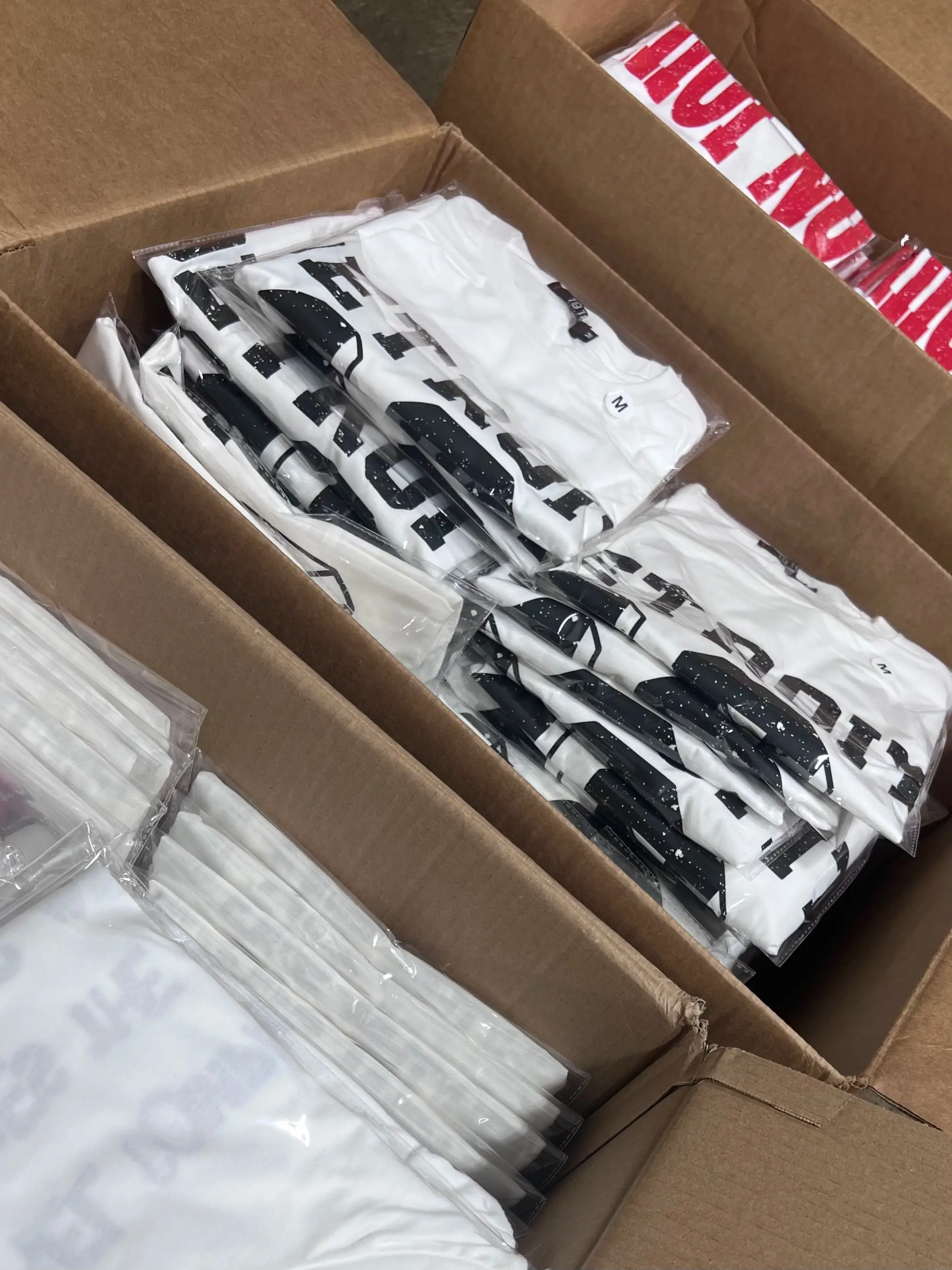 Printed white shirts individually packaged and organized in shipping boxes