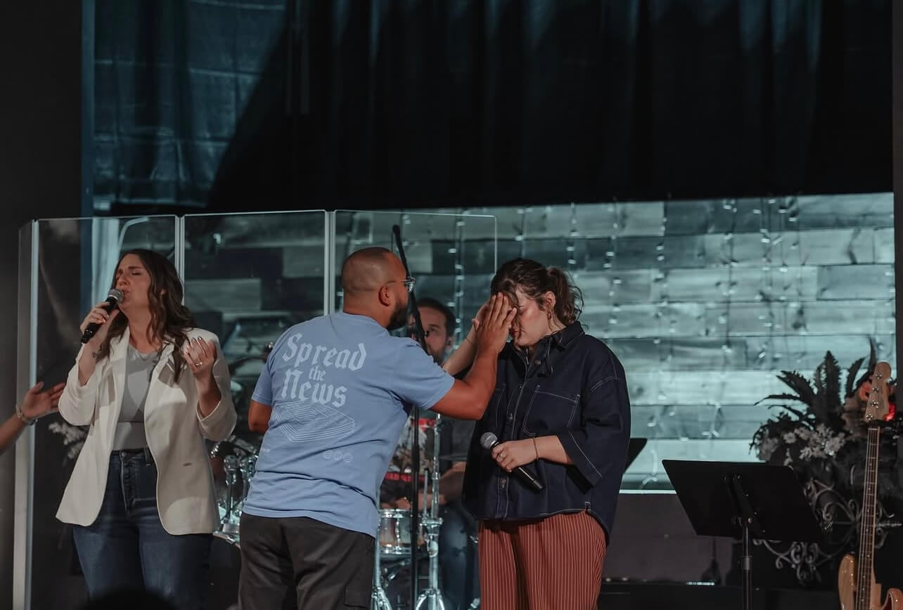 Person wearing a Spread the News church shirt during a worship gathering