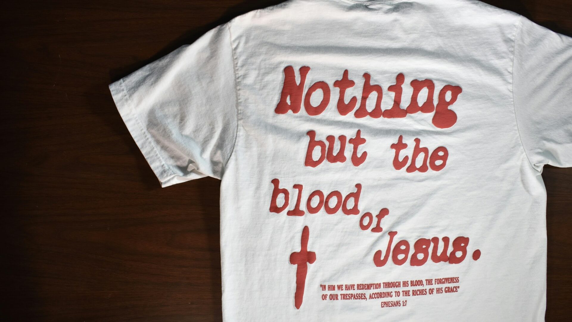 White church shirt with a red scripture-based back graphic